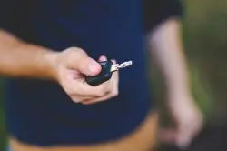 man holding car key for rental vehicle covered by car hire excess insurance